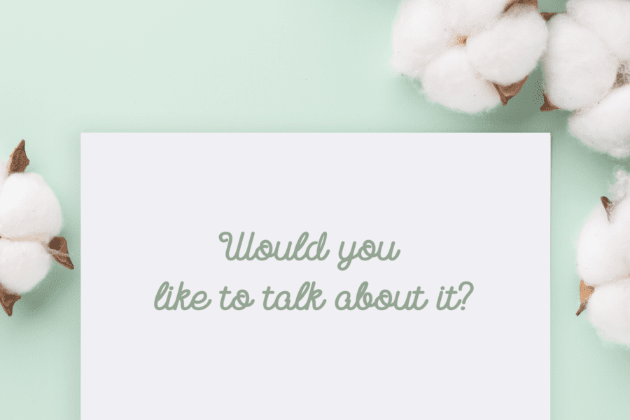 An image reflecting a card asking "Would you like to talk about it" with a soft mint green background and flowers.