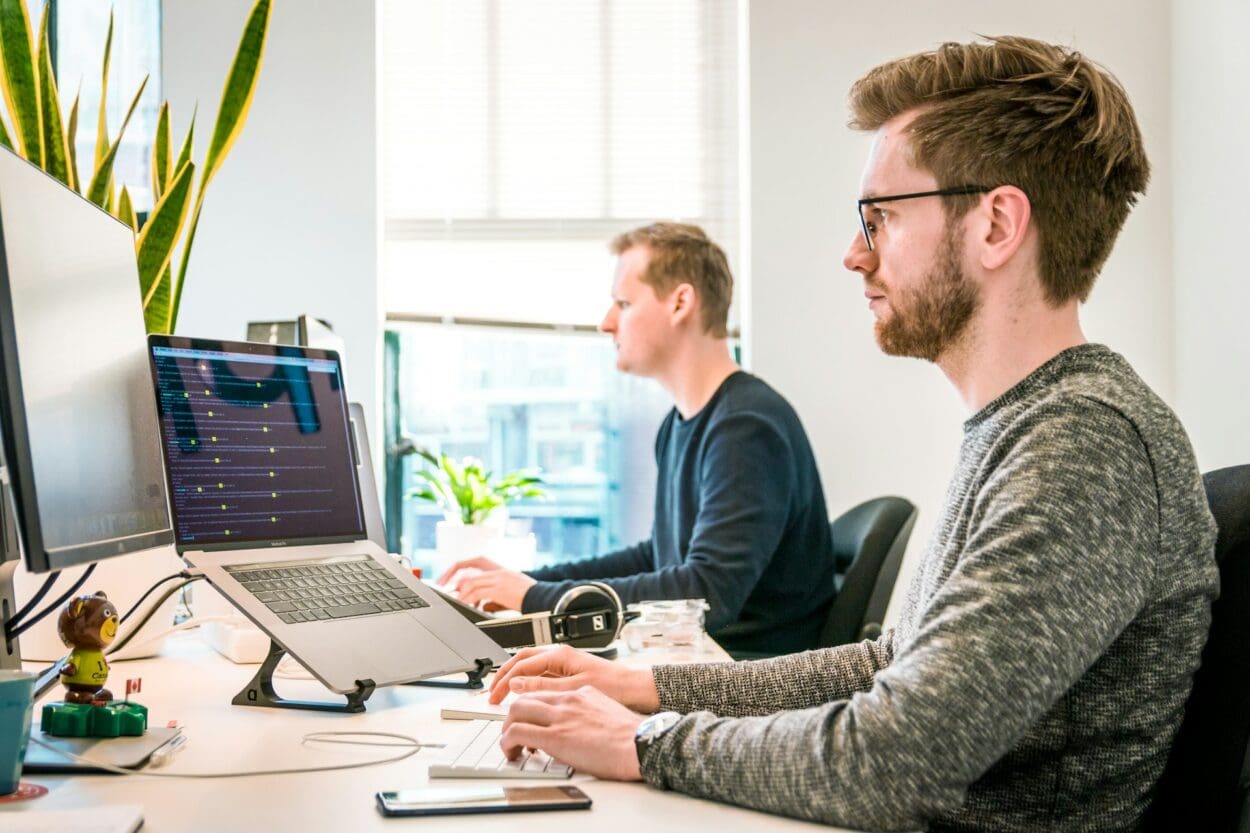 Two professionals working at desks with computers in a modern office. Getting back to work while still grieving.