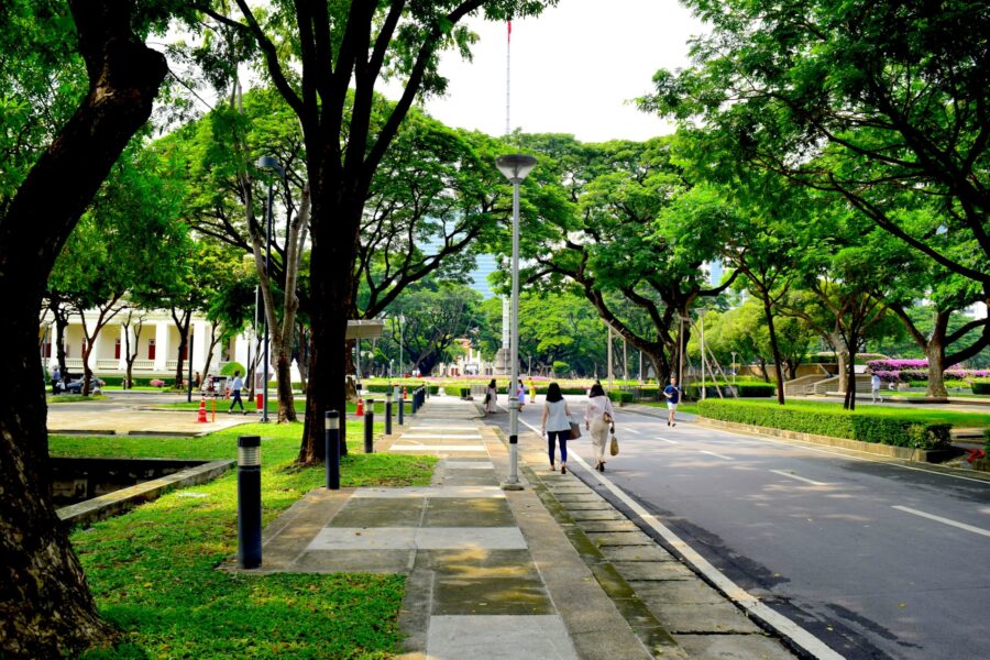 Two people walking along a tree-lined campus path, symbolizing the supportive conversation and emotional sharing about Andy’s passing.