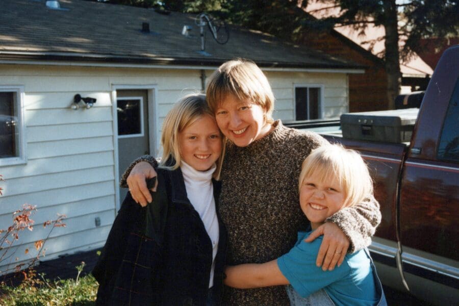 Photo of a woman embracing two young girls, capturing a joyful moment together, symbolizing cherished memories and the profound impact of sudden loss described in a blog article about grappling with the unexpected death of a beloved aunt to cancer.