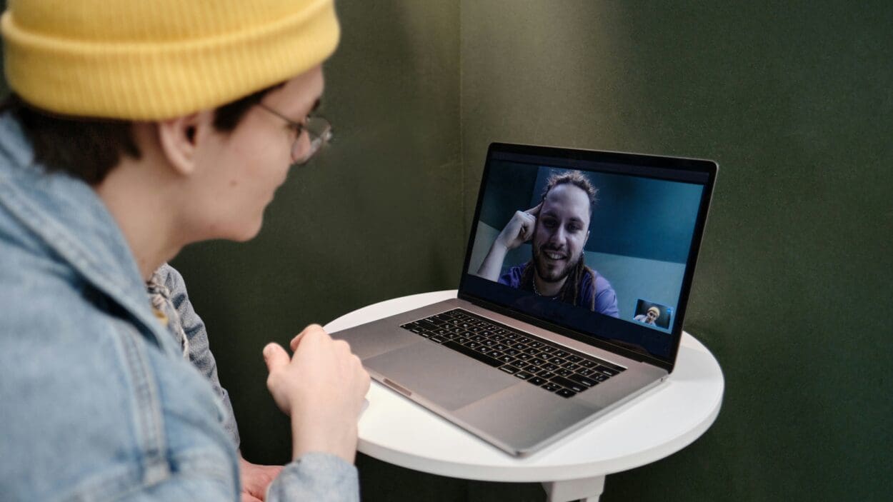 Two friends video chatting, symbolizing long-distance grieving and the importance of maintaining emotional connections and support through technology during times of loss.