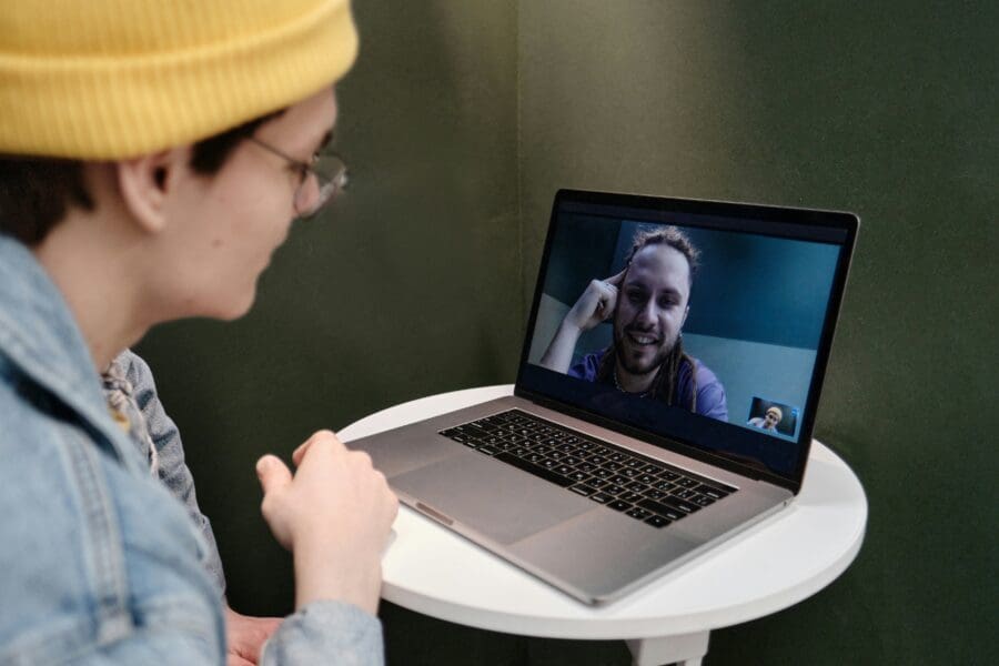 Two friends video chatting, symbolizing long-distance grieving and the importance of maintaining emotional connections and support through technology during times of loss.