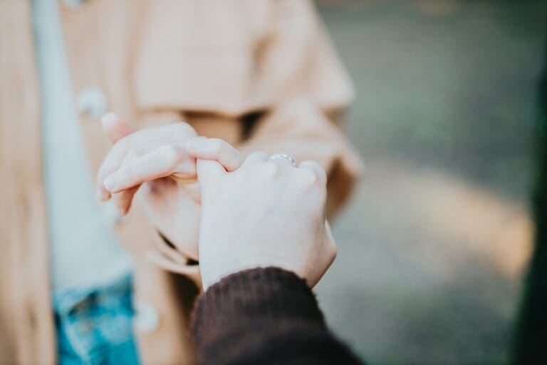 Two hands intertwined, symbolizing support and connection, capturing the emotional journey and identity loss felt by those who have ceased being caregivers.