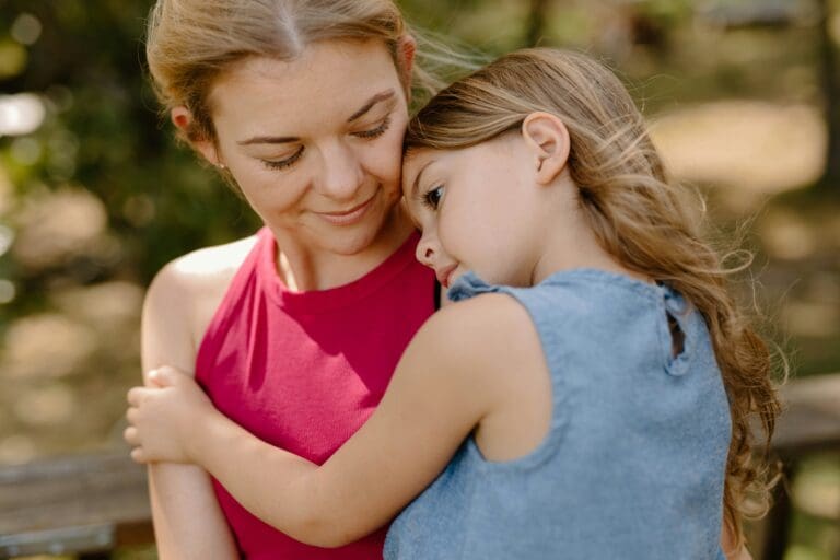 Young daugter huggin her mom, needing comfort during a time of grief, and losing a sibling.