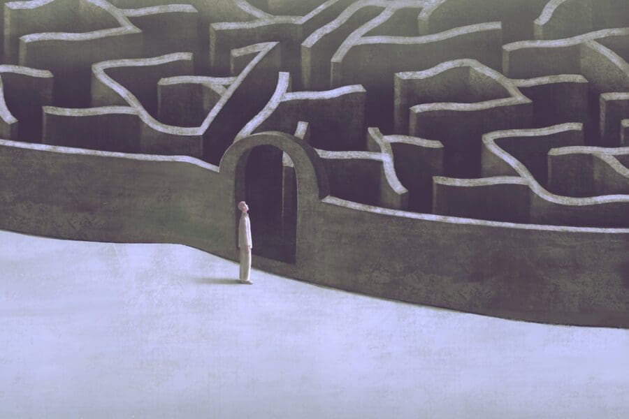 A figure stands at the entrance of a complex maze, symbolizing the daunting and intricate journey through the psychological impacts of losing a loved one to suicide.